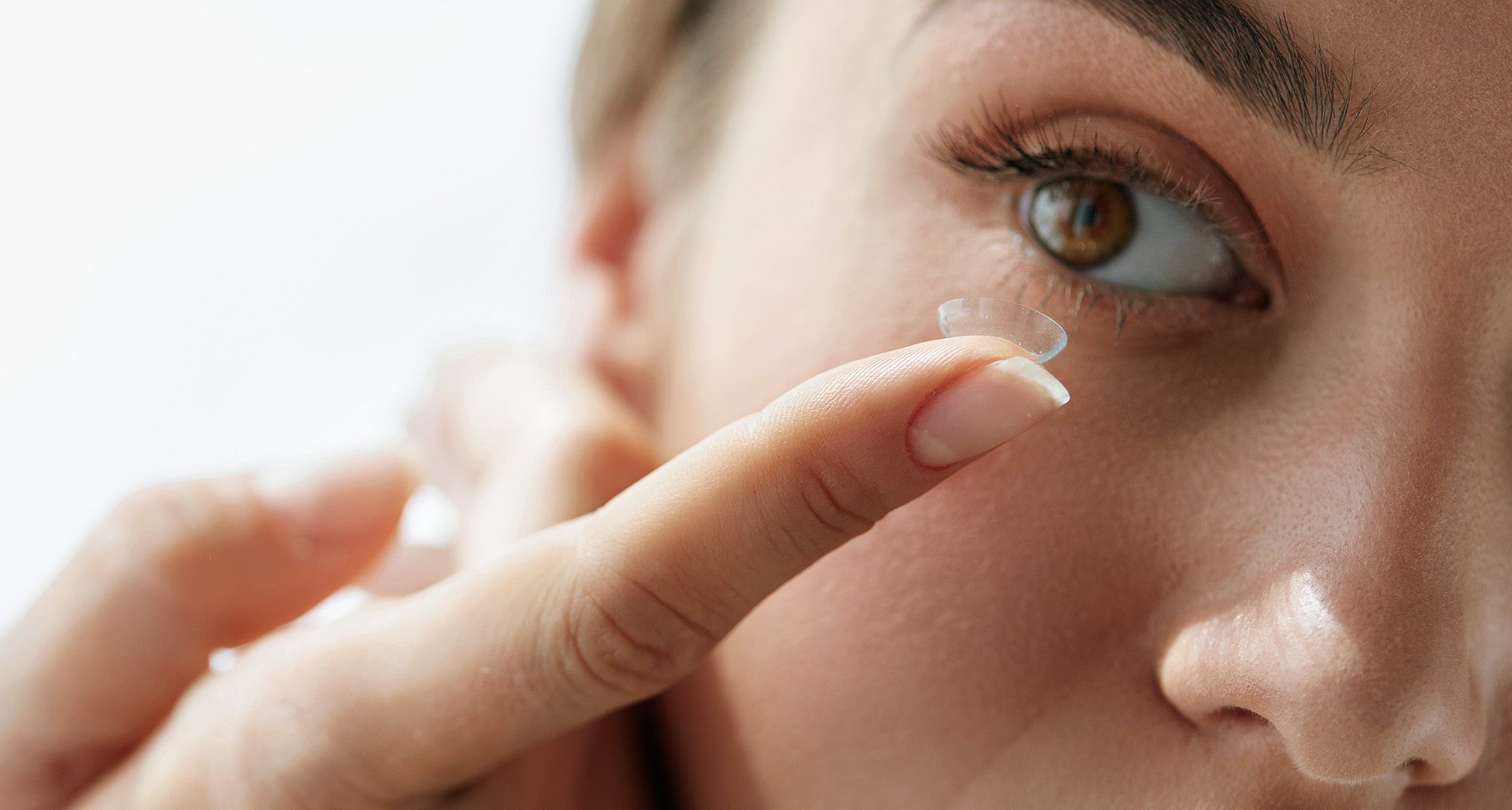 close up image of person putting in contact lens