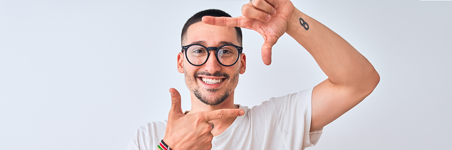 Man wearing sunglasses, measuring his face shape with his hands.