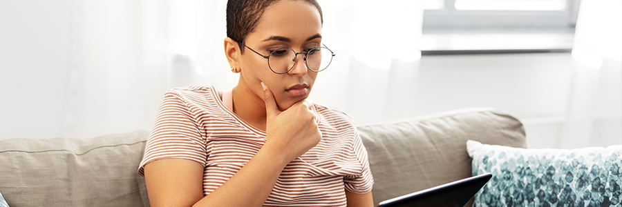 person wearing glasses looking at tablet