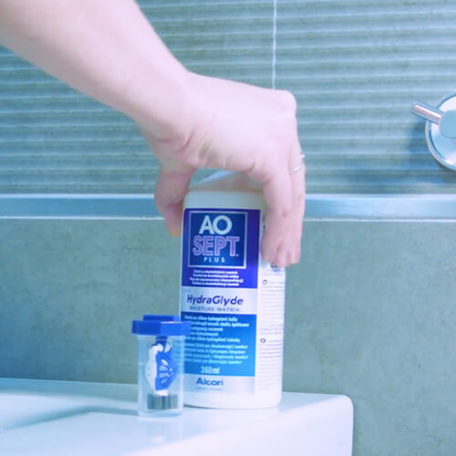 Hydrogen peroxide and case sitting on counter with a hand